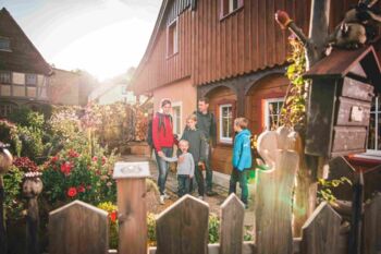 Familie im Blumengarten vor Umgebindehaus © Philipp Herfort photography